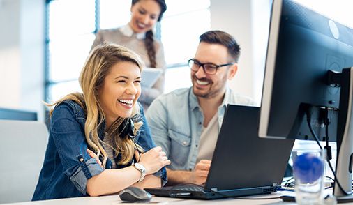 Employees pictured smiling in office, representing Westwind as a Value-Added Reseller, committed to partnerships, and helping customers to find the best solution for their organization.