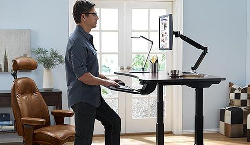 Man standing and working ergonomically at sit-stand desk