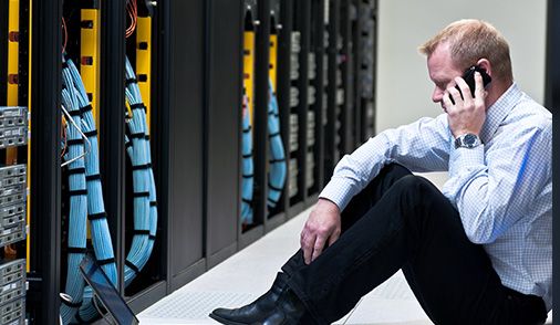 Man pictured sitting on floor of Data Center as he tests and develops App.